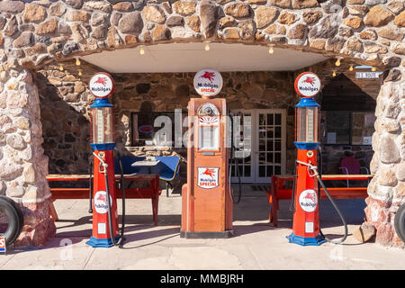 Old Mobilgas pumps displayed in front of a refurbished service station used as a snack and gift shop along the r Stock Photo