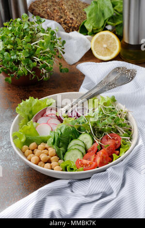 A beautiful Mediterranean salad of delicate leaves of lettuce and spinach, with the addition of Nuta, slices of fresh radish, tomato, cucumber and mic Stock Photo