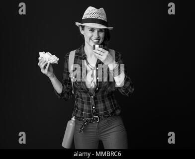 Searching for inspiring places. happy young traveller woman in a plaid shirt having meal break against background Stock Photo
