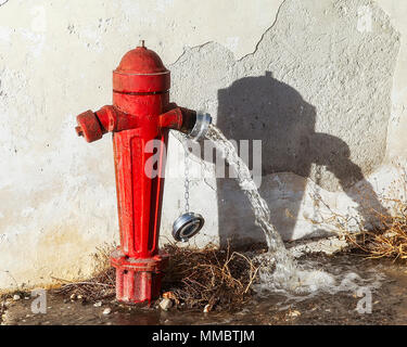 Fire hydrant  outside on a side street  with valve open. Stock Image. Stock Photo