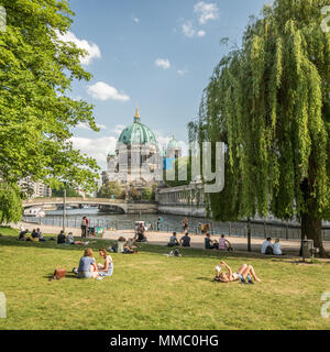 People relaxing by the Spree River with the Berlin Cathedral in the background, Berlin, Germany. Stock Photo