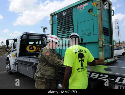 249th Engineer Battalion (Prime Power) is a United States Army unit specializing in large-scale electrical power generation and distribution. The archival image records a noncommissioned officer reviewing generator installation paperwork with a contractor at Fort Buchanan, Puerto Rico, on October 8, 2017, during Hurricane Maria disaster response operations. Stock Photo