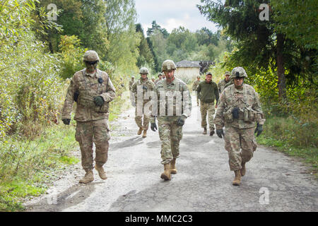 Brig. Gen. Louis Wilham, interim adjutant general of Oklahoma, (center) discusses training Ukrainian soldiers with Staff Sgt. Jeff Leggett, a Stillwater, Oklahoma resident serving with the 45th Infantry Brigade Combat Team in Ukraine, (left) and Col. David Jordan, commander of the 45th IBCT, (right) during his visit to the Yavoriv Combat Training Center on the International Peacekeeping and Security Center in Western Ukraine, on Oct. 6. (Photo by Sgt. Anthony Jones, 45th Infantry Brigade Combat Team) Stock Photo