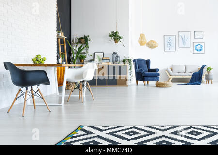 White apartment with wood table, chairs and open living room Stock Photo