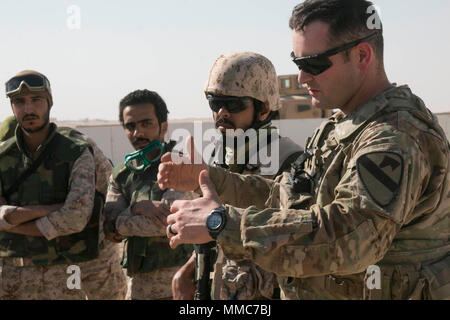 Capt. Ross Mitchell, commander of Bravo Company, 2nd Battalion, 7th Cavalry Regiment 'Ghost,' 3rd Armored Brigade Combat Team, 1st Cavalry Division, gives feedback on the conduct of the training event after the conclusion of Desert Wall at Camp Buehring, Kuwait, Oct. 5. Desert Wall was a partnership training event designed to build interoperability between the Ghost Battalion and Kuwait's 55th Battalion, 26th Brigade 'The Wall Brigade,' inspire confidence in each other's capabilities, and posture both elements for combined operations in support of Operation Spartan Shield while supporting the  Stock Photo