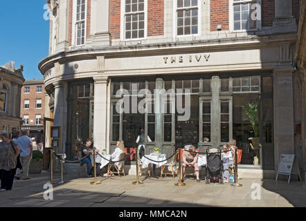 People sitting dining outside The Ivy restaurant in spring St Helens Square York city town Centre North Yorkshire England UK United Kingdom Britain Stock Photo