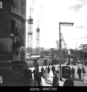 1960s, rail commuters walking towards waterloo railway station, on the south bank, London, England, UK. A crane can be seen on the foreground, as massive construction or building works were taking pace at this time on the South Bank of the River Thames, including the building of the Shell Centre, an enormous office tower block. Stock Photo