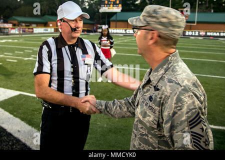 Chief Master Sgt. Jarrod Sebastian, 23d Wing command chief, receives a coin from Michael Lester, college football referee, prior to a military appreciation day game, Oct. 15, 2017, in Valdosta, Ga. Active-duty and retired military members received free admission into the game as appreciation for their service. (U.S. Air Force photo by Airman Eugene Oliver) Stock Photo