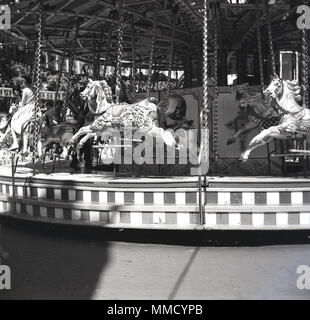 1960s, historical, young girl riding a wooden horse on a carousel or merry-go-round at the fun fair at Battersea Park, London, England, UK. The fairground was built for the 1951 Festival of Britain celebrations in the nothern section of the park and was a major attractions for many years. Stock Photo