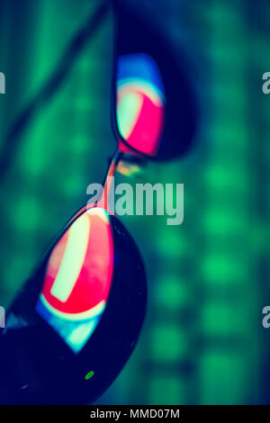 Dark sunglasses with reflection of a prohibiting road sign against a computer keyboard in the dark. The concept of anonymity in the Internet. Hacker a Stock Photo