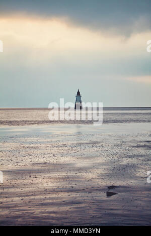 A portrait of Plover Scar lighthouse, surrounded by the incoming tide late in the evening Stock Photo