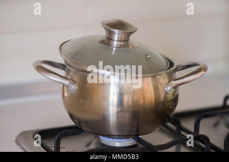 the pan is on the stove with the gas turned on Stock Photo