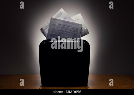Office shredder and personal documents being shredded. Stock Photo