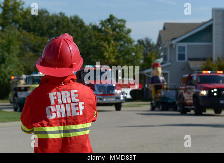 Members of Team Whiteman participate in the main event for Fire Prevention Week at Whiteman Air Force Base, Mo., Oct. 14, 2017. The main event included a base parade with firefighters assigned to the 509th Civil Engineer Squadron, Smokey the Bear, Sparky the Fire Dog and other local community fire departments. After the parade, the main event included free food, fire prevention items, fire prevention training, and inflatable bounce castles for the children. Stock Photo