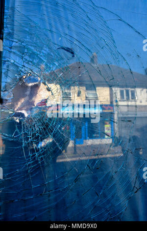 Shattered glass window with refection of buildings Stock Photo