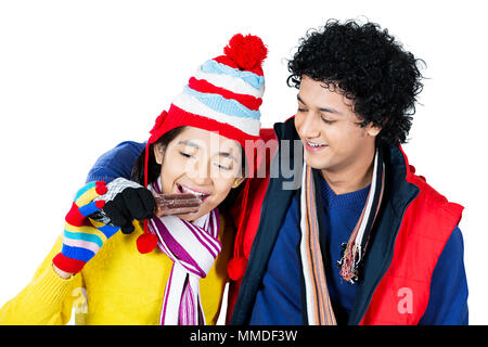 Two Young Couple In-Winter Clothes sharing Ice Cream eating Together Stock Photo