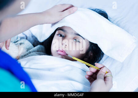 Sick Girl Lying-Bed Mother checking temperature with thermometer, High-Fever At Home Stock Photo