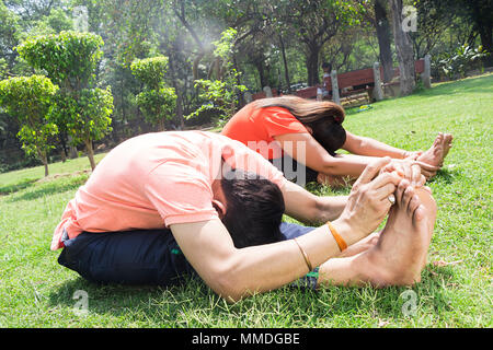 Two Couple Fitness Exercise Stretching Yoga Morning Workout In-Park Stock Photo