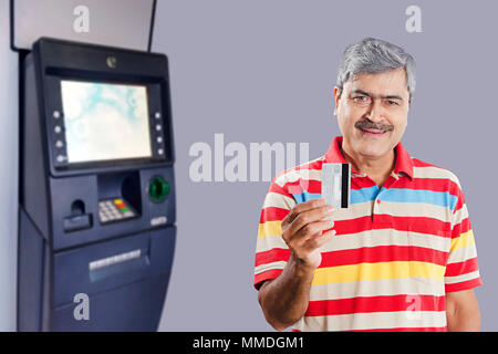 Senior Man withdrawing money from Debit card at ATM Machine Stock Photo