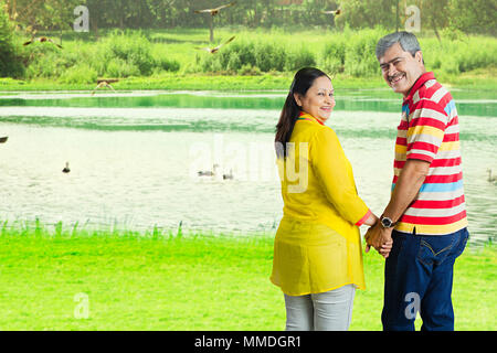 Aged Romantic Couple Hand-Holding Loving Dating Fun Enjoy Lake In-park Stock Photo