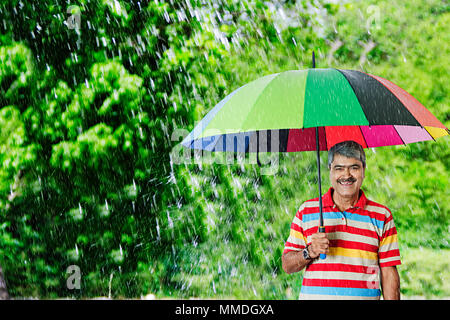 Smiling OLd Male Under Umbrella Rain Protection Summer Season In-Garden Stock Photo