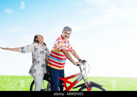 Happy Elderly Couple Together Ride Cycle Having Fun Cheerful In-Park Stock Photo