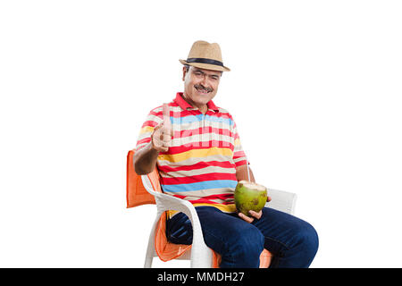 One Senior man Sitting Chair Drinking Coconut-Juice And Giving Thumbs-up Stock Photo