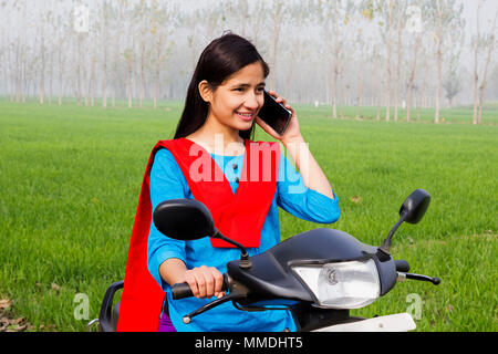 Rural Young Girl Rides Motor-Scooter And Talking Mobile Phone Farm Stock Photo