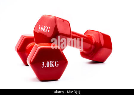 Two red dumbbells isolated on white background with copy space for text. 3.0 kg dumbbell. Weight training equipment. Bodybuilding workout accessories. Stock Photo