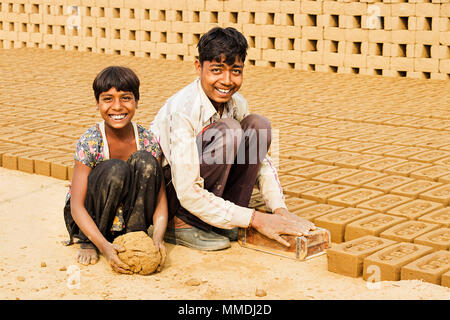 Two Boy,Girl Workers to make Bricks In brick-factory Village Stock Photo