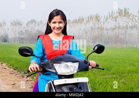 One Villager Young Girl Rides A Motor-Scooty Enjoy In-Farm Rural-Village Stock Photo