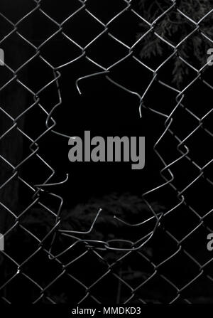 Ripped wire fence with black background. Stock Photo