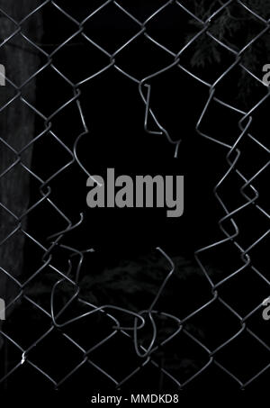 Ripped wire fence with black background. Stock Photo