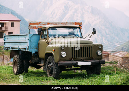 Georgia. GAZ-53 - Old Soviet Russian medium-duty truck parking near village on summer mountains landscape background in Darial Gorge, Georgia. Stock Photo