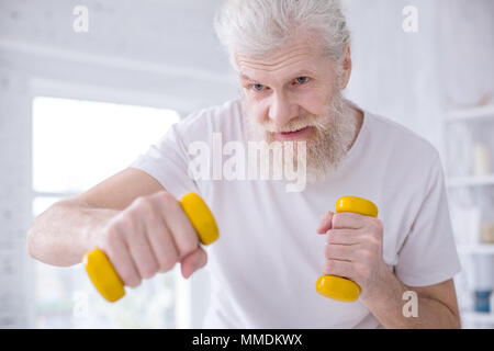Close up of elderly man practicing boxing jabs with dumbbells Stock Photo