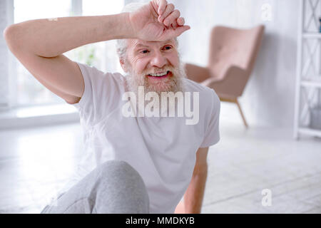 Cheerful senior man wiping off sweat after exercise Stock Photo