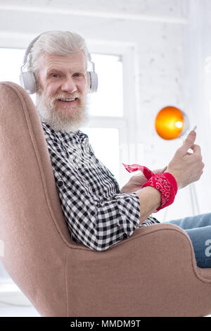 Charming elderly man posing while using tablet Stock Photo