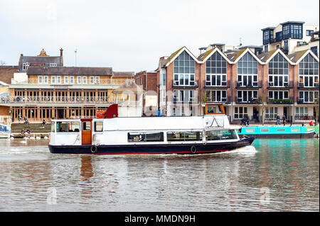 Tourist boat cruising along the River Thames passing the Riverside Walk promenade in Kingston upon Thames, England Stock Photo