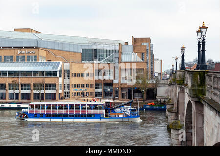 Tourist steam boat cruising along the River Thames passing John Lewis shopping mall and Kingston Bridge in Kingston upon Thames, England Stock Photo