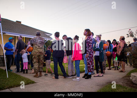 Residents of The Village at Federal City, in New Orleans, stand in line to receive a prize after participating in a pumpkin-patch dash, Oct. 17, 2017. Police officers with New Orleans Police Department, along with Marines from Marine Forces Reserve, held “A Night Out Against Crime”, a yearly, nationwide event that brings together community members in a police-to-community partnership to raise awareness of a police presence, and to build safety in surrounding areas of New Orleans. (U.S. Marine Corps photo by Cpl. Dallas Johnson/Released) Stock Photo