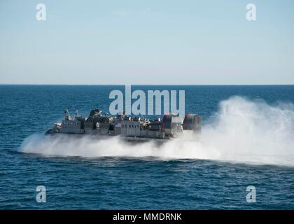 171021-N-RN119-0873 ATLANTIC OCEAN (Oct. 21, 2017) Landing craft air cushion (LCAC) 54, attached to Assault Craft Unit 4, cuts through the water to pick up cargo. LCAC 54 is on board the amphibious dock landing ship USS Gunston Hall (LSD-44) in support of exercise Bold Alligator 2017 (#BA17). Improving Navy-Marine Corps amphibious core competencies along with coalition, North Atlantic Treaty Organization (NATO) Allied and partner nations is a necessary investment in the current and future readiness of our forces. BA17 will take place Oct. 18 - 30, 2017, ashore along the eastern seaboard. (U.S. Stock Photo