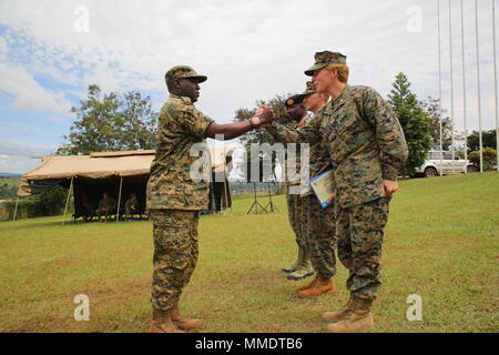 Lieutenant Col. Karin Fitzgerald, the commanding officer of Special Purpose Marine Air-Ground Task Force-Crisis Response-Africa logistics combat element, congratulates a UPDF soldier during the graduation ceremony of an eight-week training course facilitated by the SPMAGTF-CR-AF LCE service members at Camp Jinja, Uganda, Oct. 13, 2017. SPMAGTF-CR-AF Marines deployed to conduct crisis-response and theater-security operations in Europe and Africa. (U.S. Marine Corps photo by Lance Cpl. Patrick Osino) Stock Photo