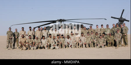 UDARI, Kuwait – Soldiers from the 29th Combat Aviation Brigade’s 1-147 Assault Helicopter Battalion, Task Force Wraith, pose with members of the Kuwait Land Forces during training rehearsals for exercise Desert Wall at Camp Buehring, Kuwait, Oct. 4, 2017. Desert Wall consisted of air and ground assault training and tested the interoperability of the Kuwait Soldiers with their U.S. counterparts. (Photo by U.S. Army Staff Sgt. Isolda Reyes) Stock Photo