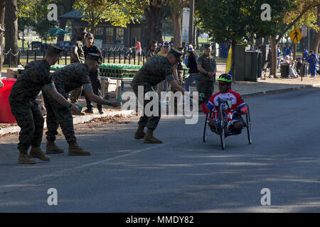 A cyclist receives water while taking part in the 42nd annual Marine Corps Marathon, traveling on a monumental course through Washington, D.C. and finishing at the Marine Corps War Memorial, Arlington, Va., Oct. 22, 2017. Also known as 'The People's Marathon,' the 26.2 mile race drew roughly 30,000 participants to promote physical fitness, generate goodwill in the community, and showcase the organizational skills of the Marine Corps. (U.S. Marine Corps photo by Lance Cpl. Brooke Deiters) Stock Photo