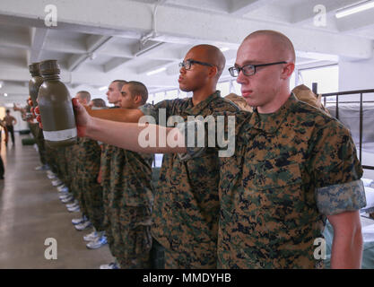 Recruits from Echo Company, 2nd Recruit Training Battalion, hold out their canteens during an initial gear inspection at Marine Corps Recruit Depot San Diego, Oct. 20. The inspection ensures the recruits have all the gear they will need for the duration of training. Annually, more than 17,000 males recruited from the Western Recruiting Region are trained at MCRD San Diego. Echo Company is scheduled to graduate Jan. 12. Stock Photo