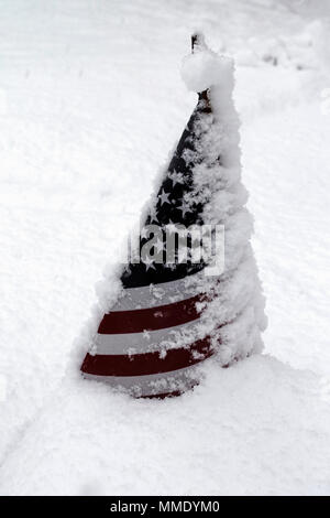 An American flag is nearly covered in deep snow during a blizzard. Stock Photo