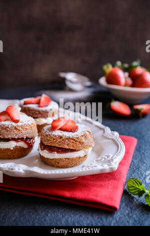 Traditional mini Victoria sponge cakes with whipped cream and strawberries Stock Photo