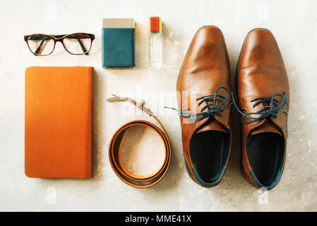 Men's accessories and shoes on gray background. Flat lay of elegant belt, glasses, parfume, notebook. Stylish set and fashion concept for man Stock Photo