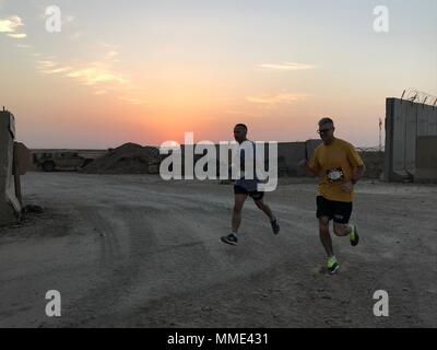 QAYYARAH AIRFIELD, Iraq – Sailors run the Marine Corps Marathon Forward in Iraq, Oct. 22, 2017. The forward deployed version of the Marine Corps Marathon was started by Maj. Megan McClung, who was the first female United States Marine Corps officer killed in combat during the Iraq War. McClung was serving as a public affairs officer in Al Anbar Province, Iraq when she was killed. Marines in deployed locations continue to run the marathon in her memory. The service members who competed in the race are deployed in support of Operation Inherent Resolve. (U.S. Navy photo by Cmdr. Paulo Hernandez) Stock Photo