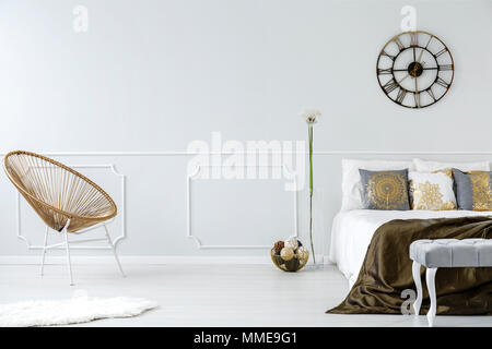 Gold bedroom interior with modern armchair, double bed and wall molding Stock Photo